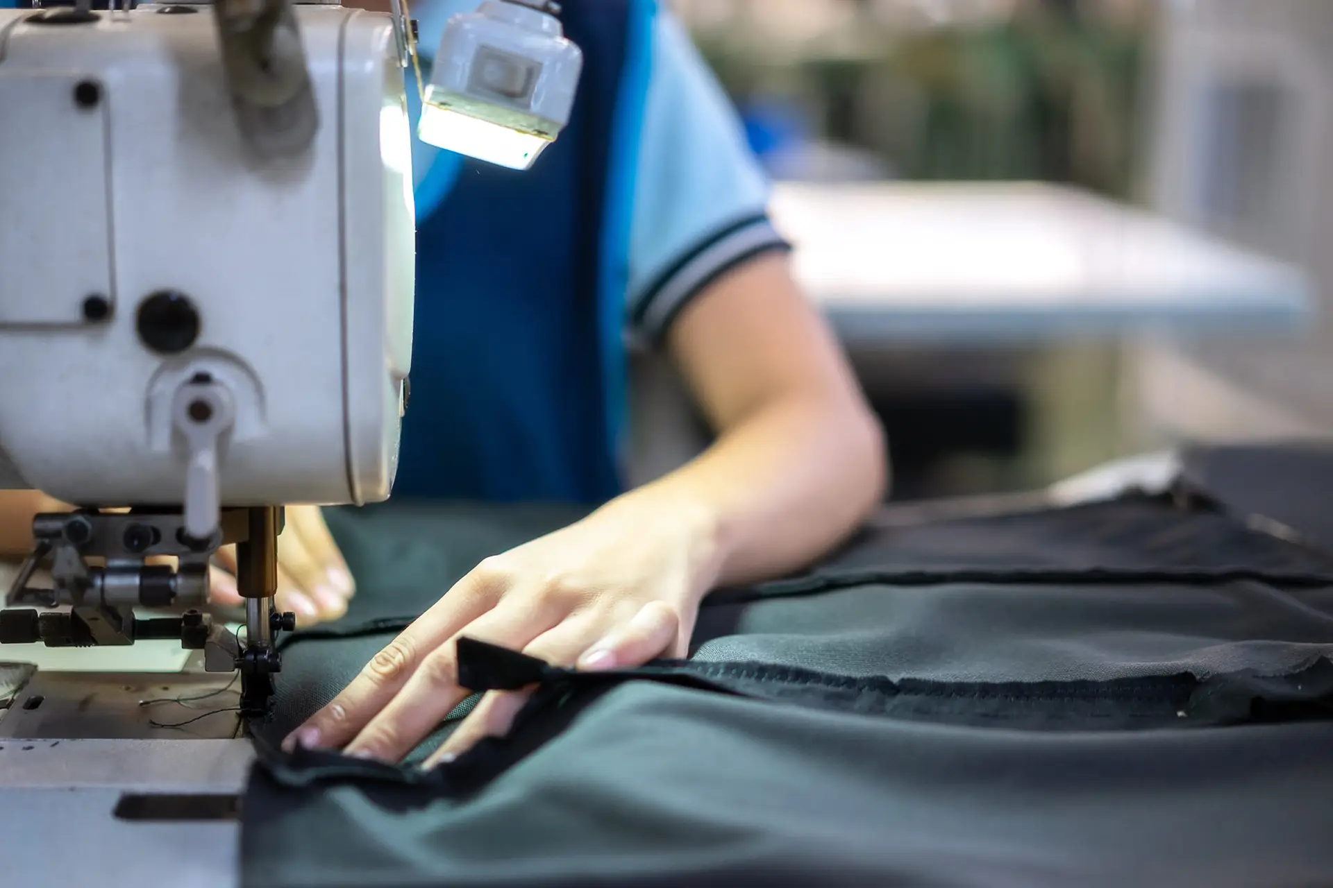 Ouvrière utilisant une machine à coudre pour la confection d'un emballage sur mesure