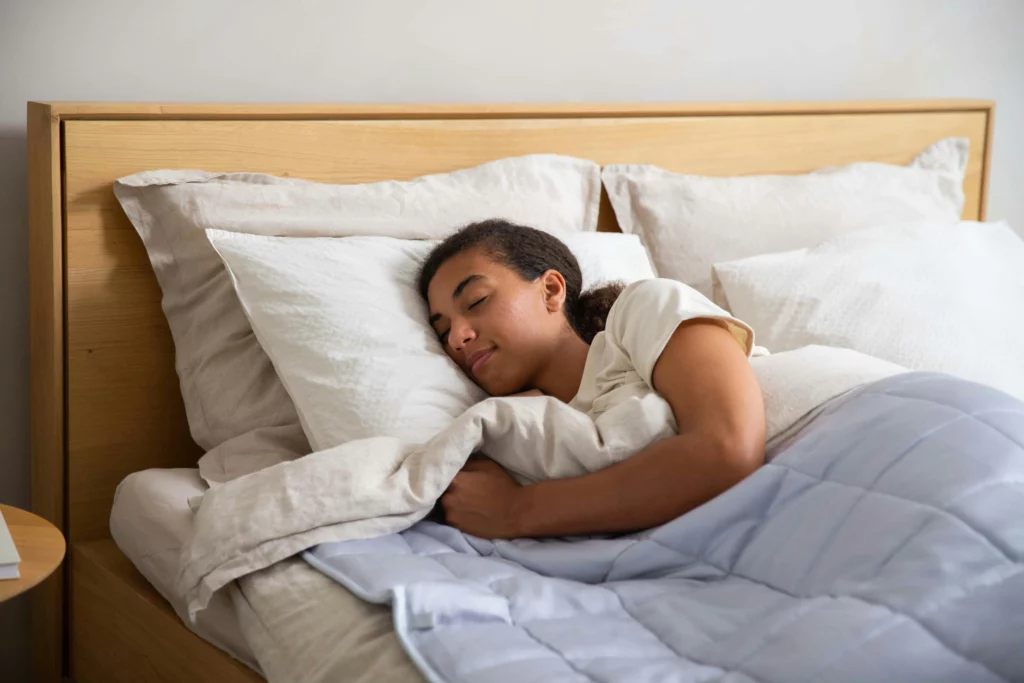 femme dormant dans un lit avec des draps en matière naturelle